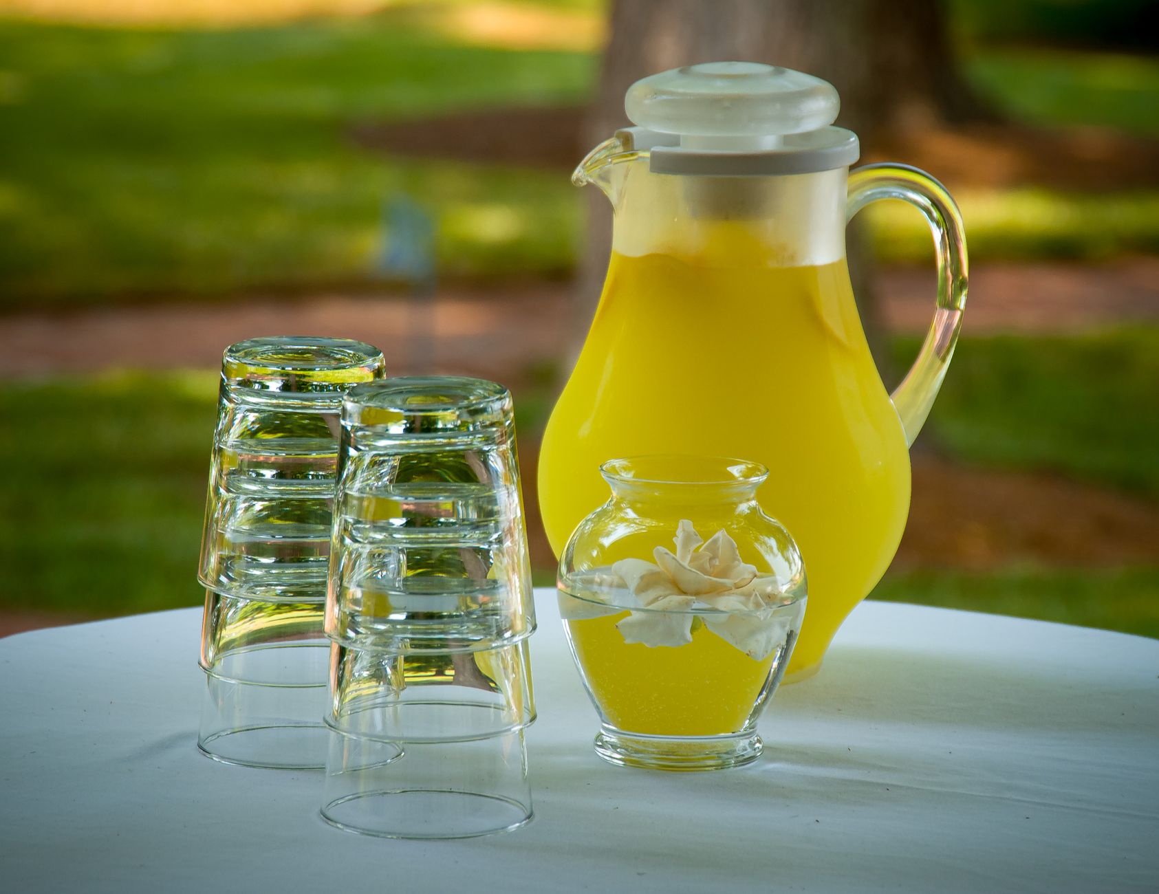Kande med limonade og glas på et bord